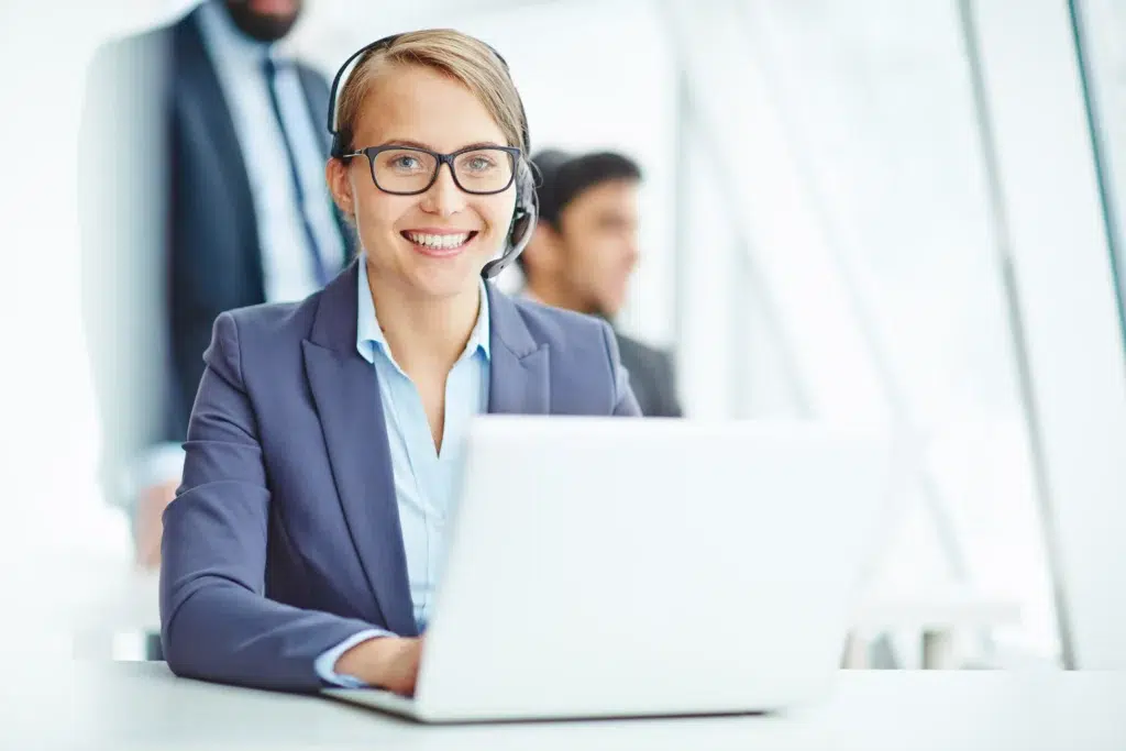 CRM virtual assistant organizing customer data on a laptop in a busy office